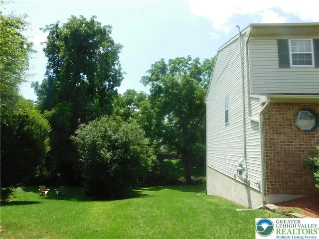 a view of backyard with potted plants and large tree