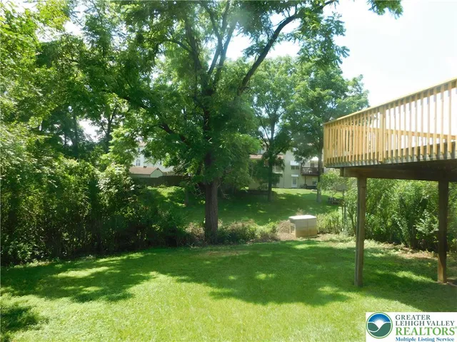 a view of backyard with swimming pool and green space