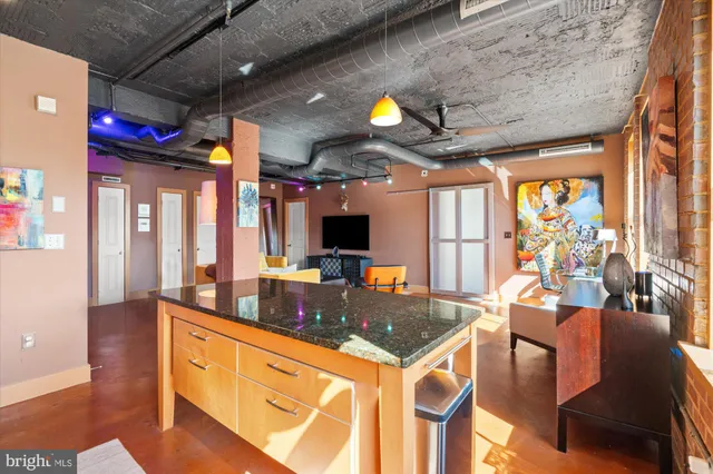 a kitchen that has a lot of cabinets a sink and a wooden floor