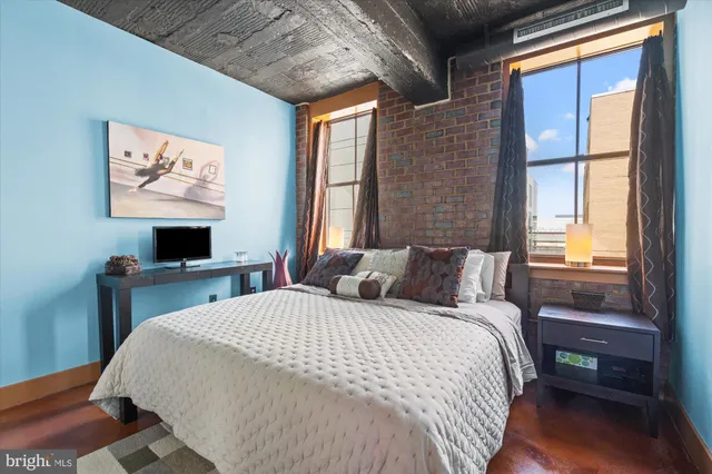 a bedroom with a bed a window and a flat screen tv