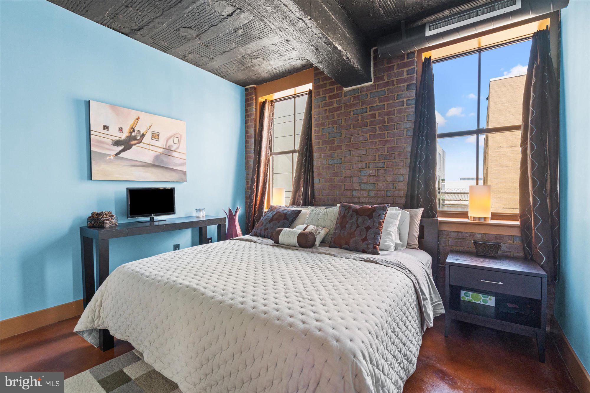 916 G St. Northwest, Unit 803 Washington, DC 20001 - Photo 22 of 27 a bedroom with a bed a window and a flat screen tv