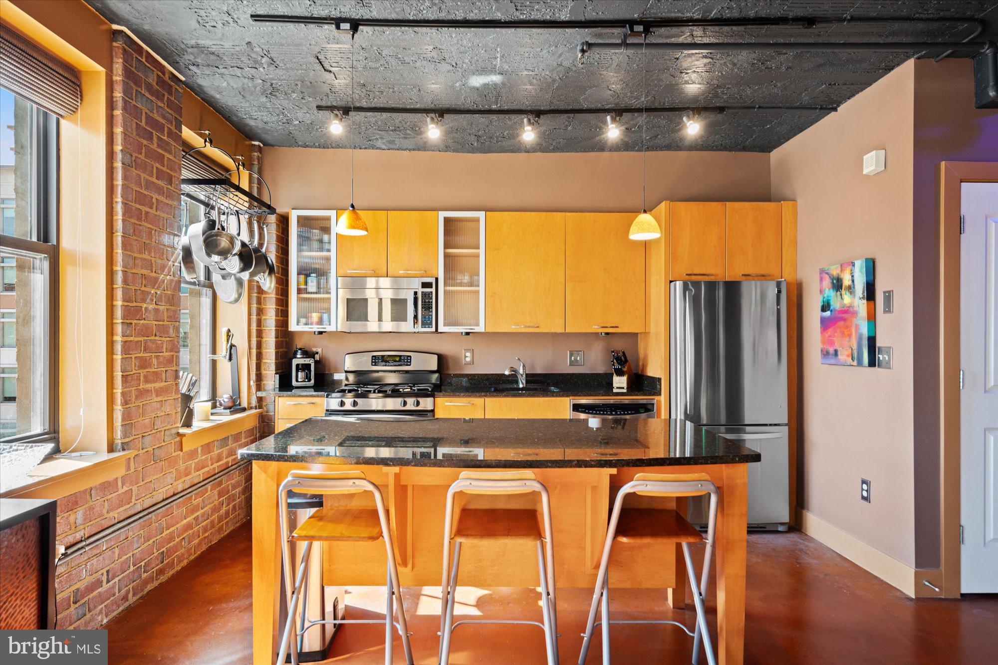 916 G St. Northwest, Unit 803 Washington, DC 20001 - Photo 8 of 27 a view of a kitchen with kitchen island granite countertop a large window and stainless steel appliances