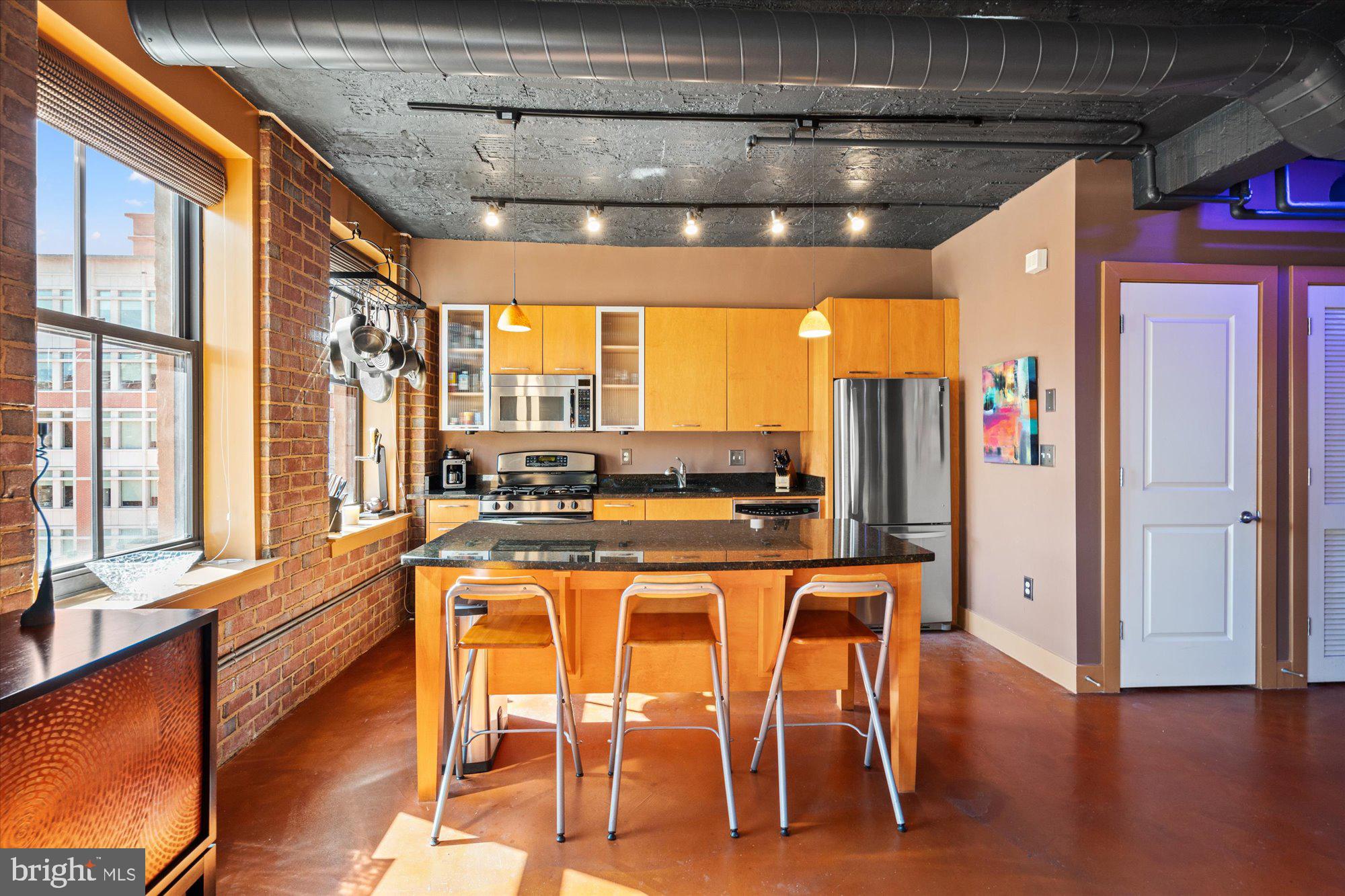 916 G St. Northwest, Unit 803 Washington, DC 20001 - Photo 10 of 27 a kitchen with stainless steel appliances granite countertop a refrigerator and wooden cabinets