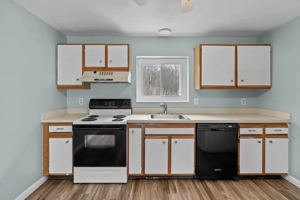 a kitchen with a stove sink and cabinets