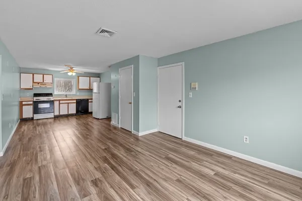 a very nice looking room with wooden floor and a view of kitchen