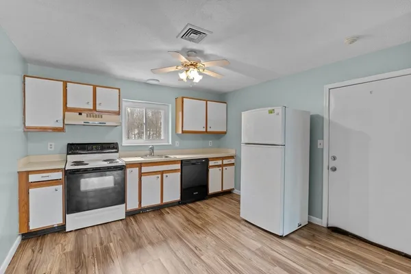 a kitchen with a refrigerator a stove top oven a sink and cabinets