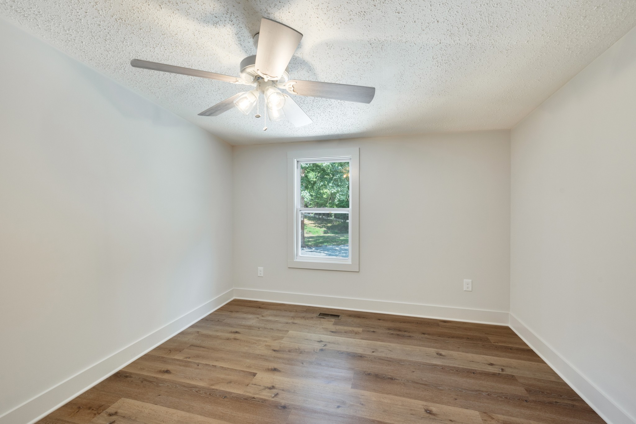 9064 New Chapel Road Springfield, TN 37172 - Photo 15 of 33 an empty room with wooden floor fan and windows