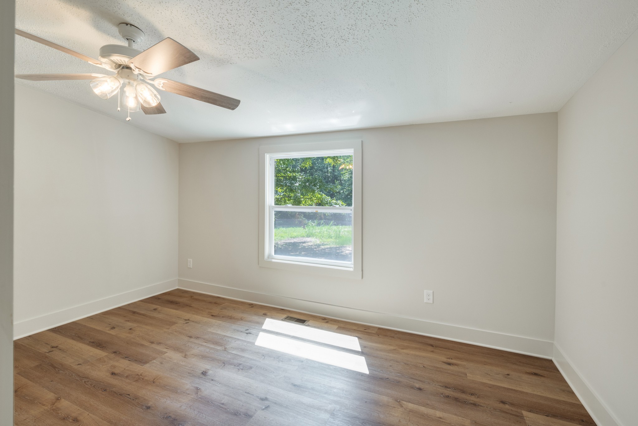 9064 New Chapel Road Springfield, TN 37172 - Photo 17 of 33 an empty room with wooden floor fan and windows