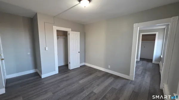 a view of a kitchen with a refrigerator and wooden floor