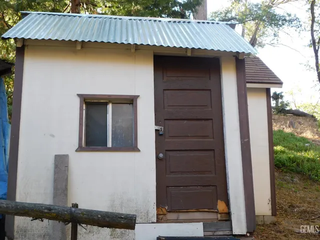 a view of a house with a door and wooden wall