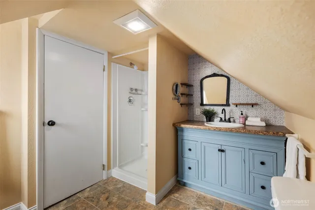 a bathroom with a granite countertop sink and a mirror