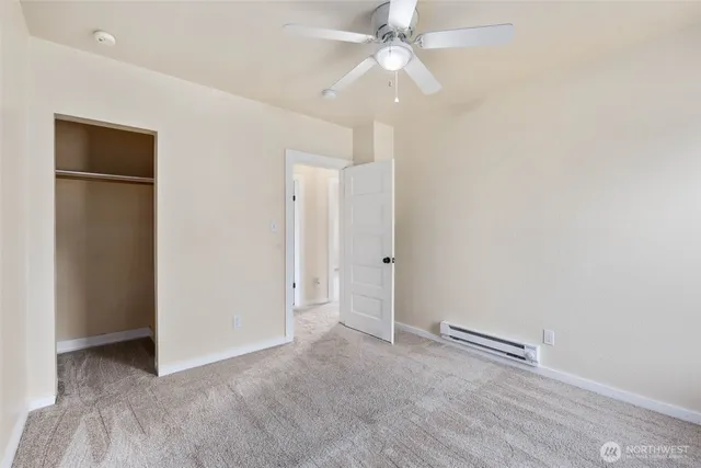 an empty room with a ceiling fan and a window