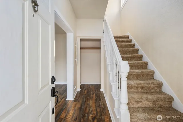 a view of a hallway with wooden floor and staircase