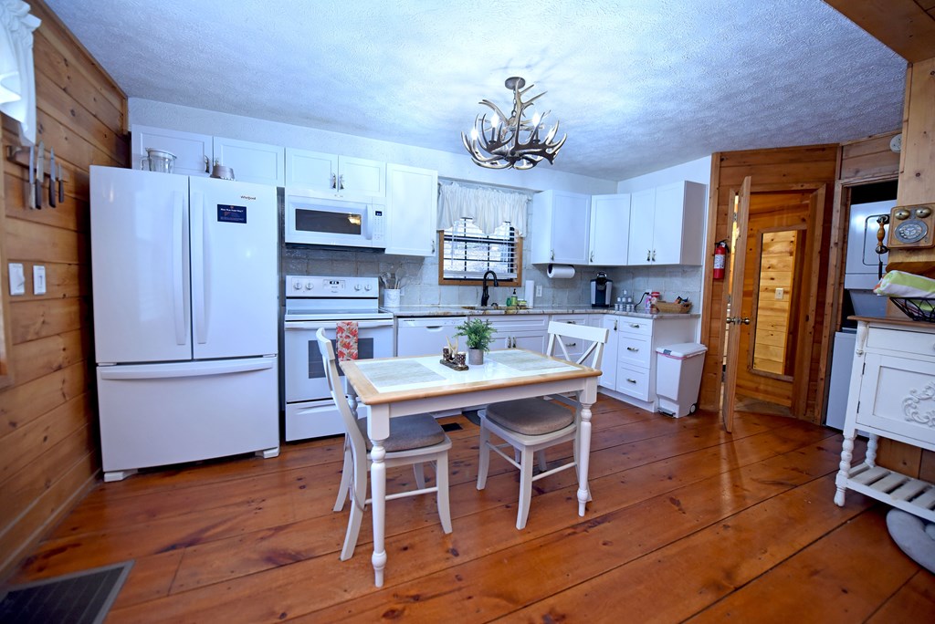 266 Mabry Lane Morganton, GA 30560 - Photo 11 of 37 a kitchen with stainless steel appliances a refrigerator a stove a sink dishwasher and a dining table with wooden floor