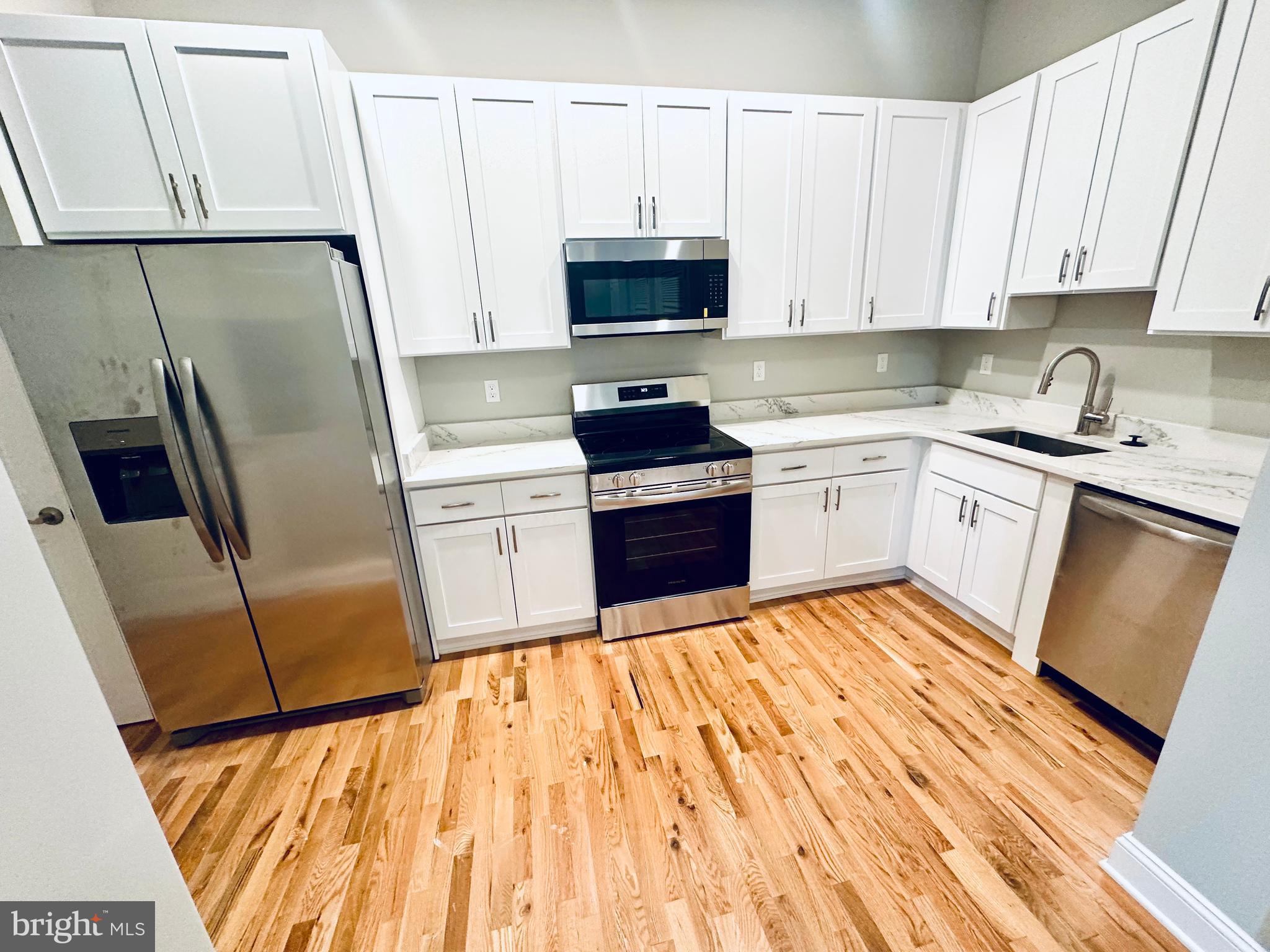 100 West Lexington Street, Unit 305 Baltimore, MD 21201 - Photo 13 of 38 a kitchen with stainless steel appliances a refrigerator sink and microwave
