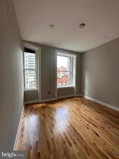 100 West Lexington Street, Unit 305 Baltimore, MD 21201 - Photo 29 of 38 an empty room with wooden floor and windows