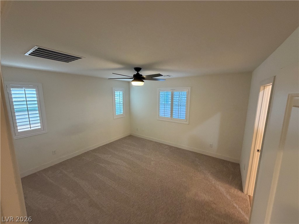 7879 Shoreline Ridge Court Las Vegas, NV 89166 - Photo 11 of 26 Plush carpeting and plantation shutters define this inviting bedroom space.