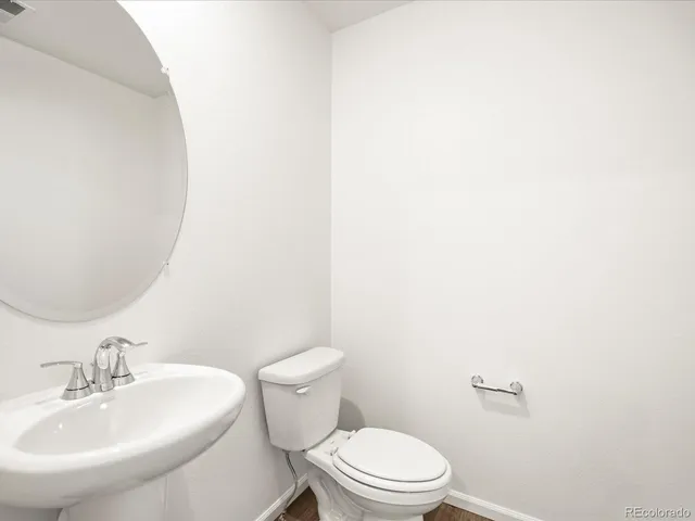 a bathroom with a toilet a sink and mirror