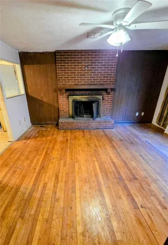 a view of empty room with wooden floor and fireplace