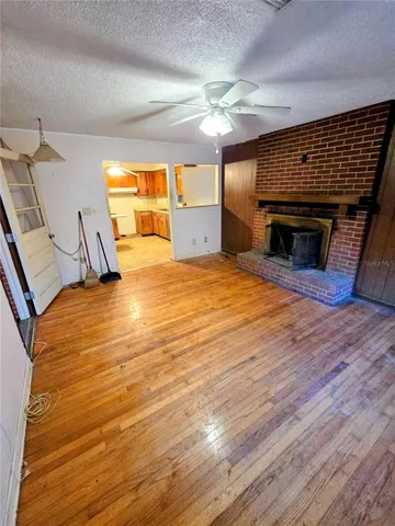 a view of empty room with wooden floor and fireplace