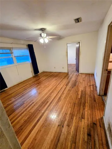 a view of empty room with wooden floor