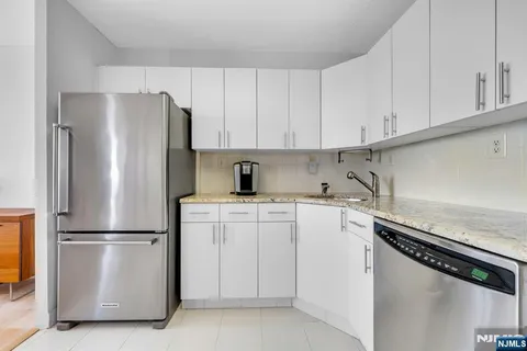 a kitchen with appliances a refrigerator a sink and cabinets