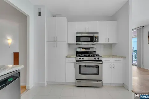 a kitchen with white cabinets and stainless steel appliances