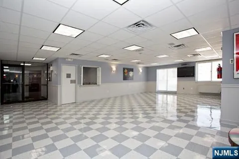 a view of a hall with a dining table chairs