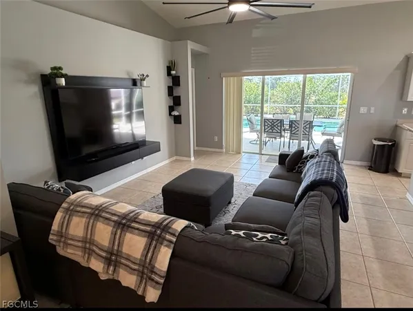 a living room with furniture a flat screen tv and a large window