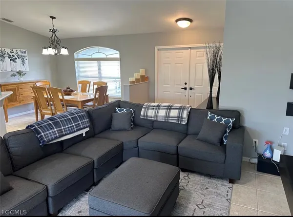 a living room with furniture and a chandelier