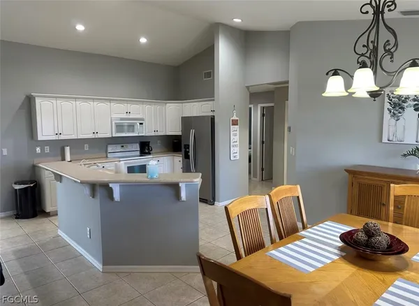 a kitchen with stainless steel appliances granite countertop a sink dishwasher a refrigerator and a stove with wooden floor