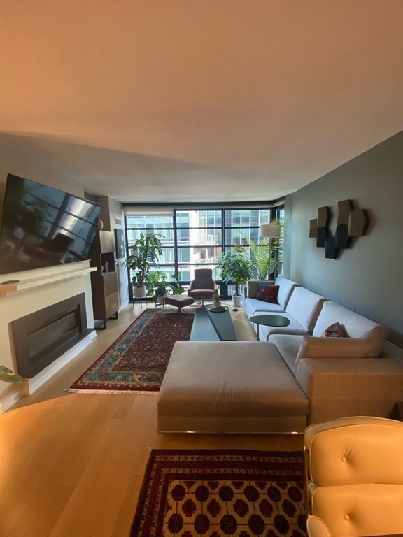 580 Washington Street, Unit 711 Boston, MA 02111 - Photo 1 of 7 a living room with furniture and a flat screen tv