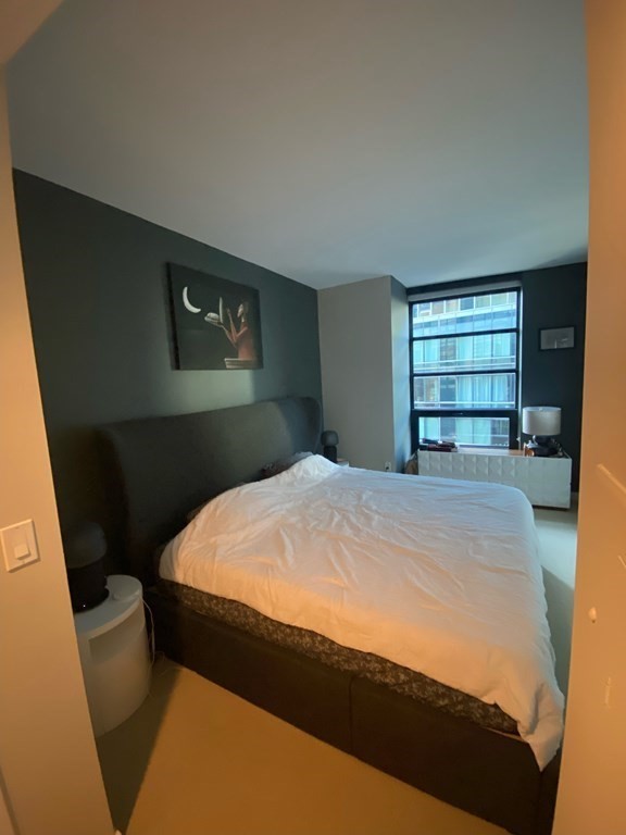 580 Washington Street, Unit 711 Boston, MA 02111 - Photo 4 of 7 a bed sitting in a bedroom next to a window