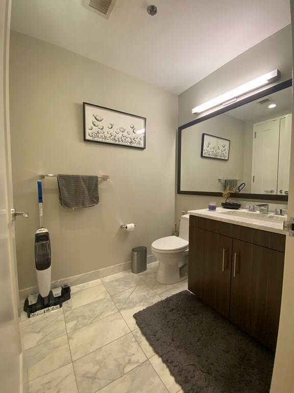 580 Washington Street, Unit 711 Boston, MA 02111 - Photo 7 of 7 a spacious bathroom with a sink and a mirror