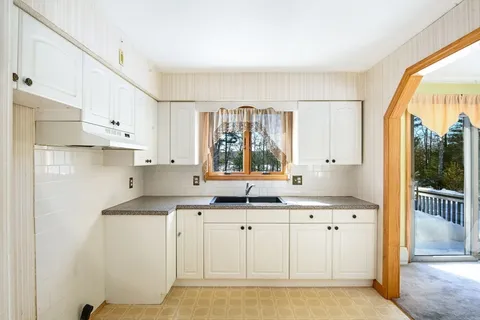 a kitchen with granite countertop a sink cabinets and window