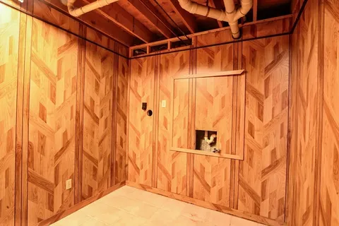 a view of walk in closet with wooden walls