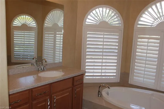 a bathroom with a bathtub a sink and a window