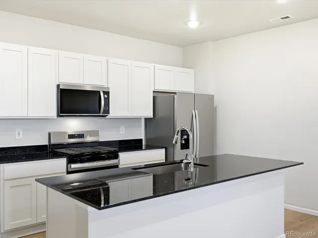 a kitchen with stainless steel appliances a refrigerator a stove a microwave and cabinets