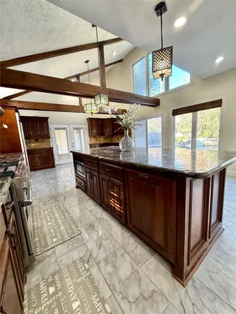 a kitchen with stainless steel appliances granite countertop a stove a sink and a refrigerator