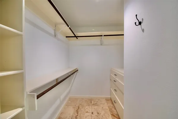 an empty room with wooden floor chandelier fan and windows