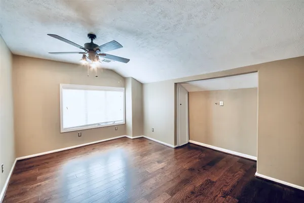 an empty room with a window and a ceiling fan