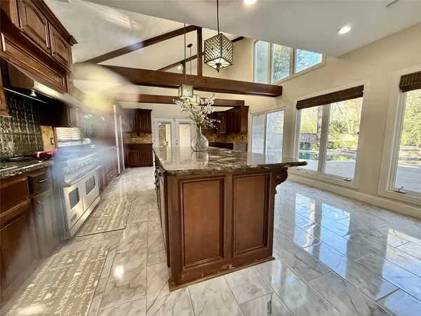 a kitchen with stainless steel appliances granite countertop a stove a sink and a refrigerator