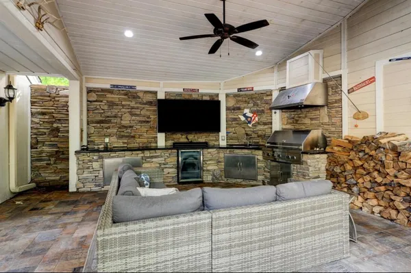 a living room with furniture a flat screen tv and a large window