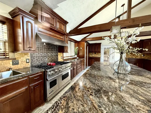 a kitchen with stainless steel appliances granite countertop a stove a sink and a microwave