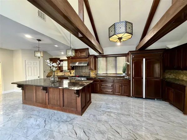 a kitchen with stainless steel appliances granite countertop a stove a sink dishwasher and a refrigerator