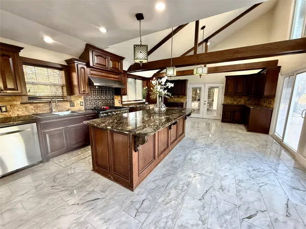 a kitchen with stainless steel appliances granite countertop a stove a sink and a refrigerator