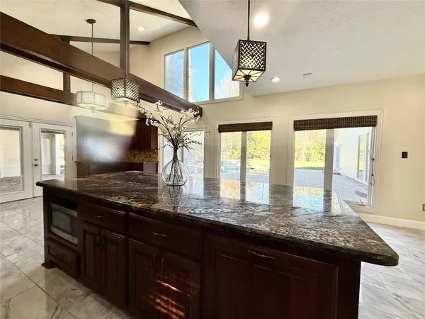 a kitchen with granite countertop a sink and wooden cabinets