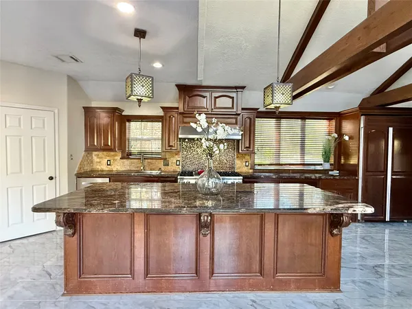 a kitchen with stainless steel appliances granite countertop a sink window and cabinets