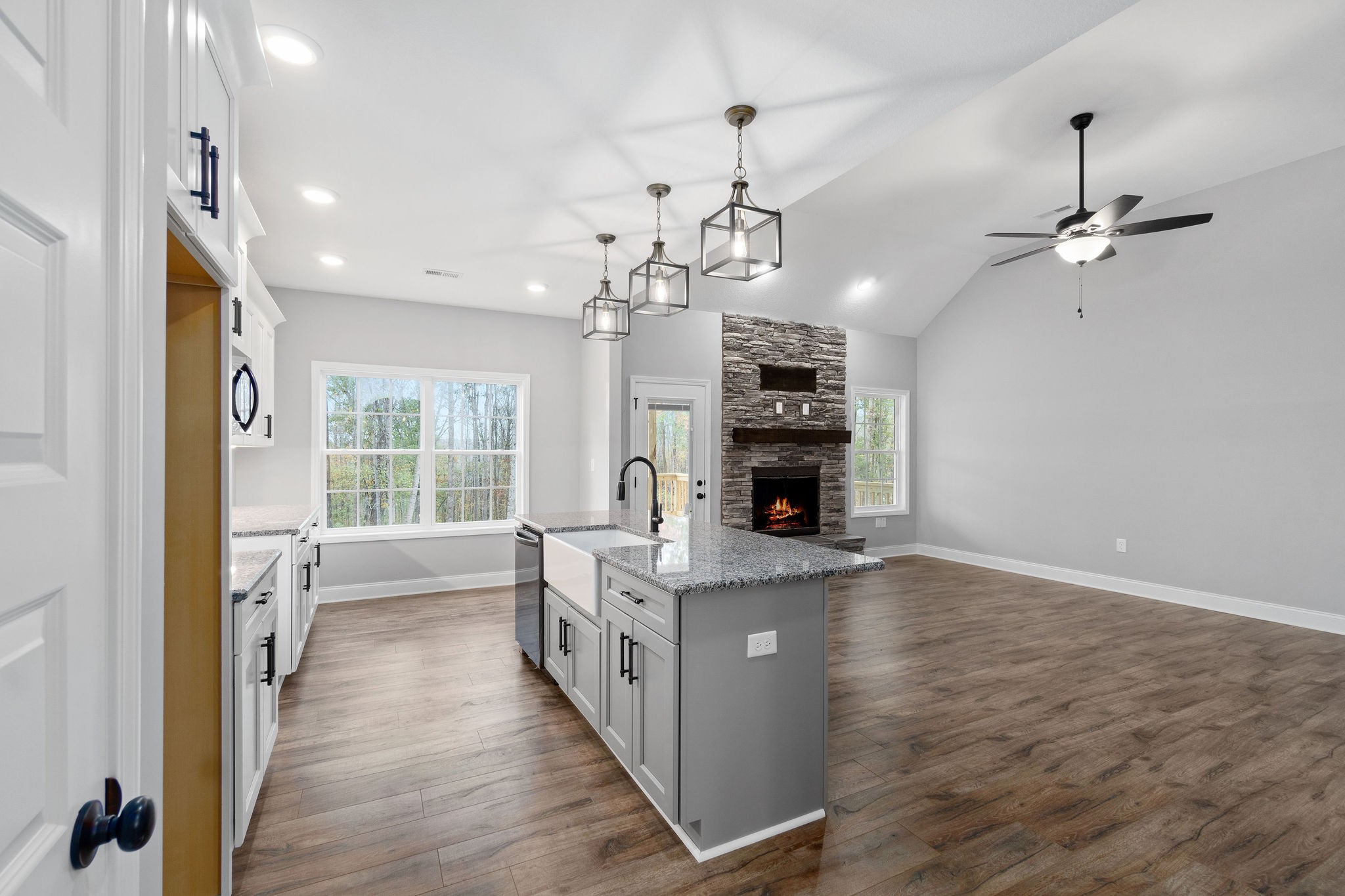 2790 Russell Road Palmyra, TN 37142 - Photo 11 of 31 a open kitchen with kitchen island a stove a wooden floor and a chandelier