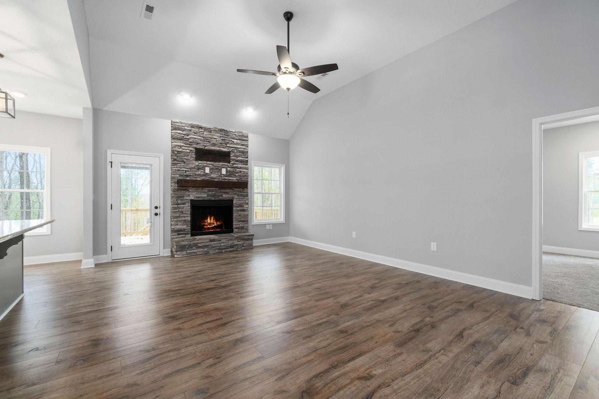 2790 Russell Road Palmyra, TN 37142 - Photo 5 of 31 an empty room with wooden floor fireplace and windows